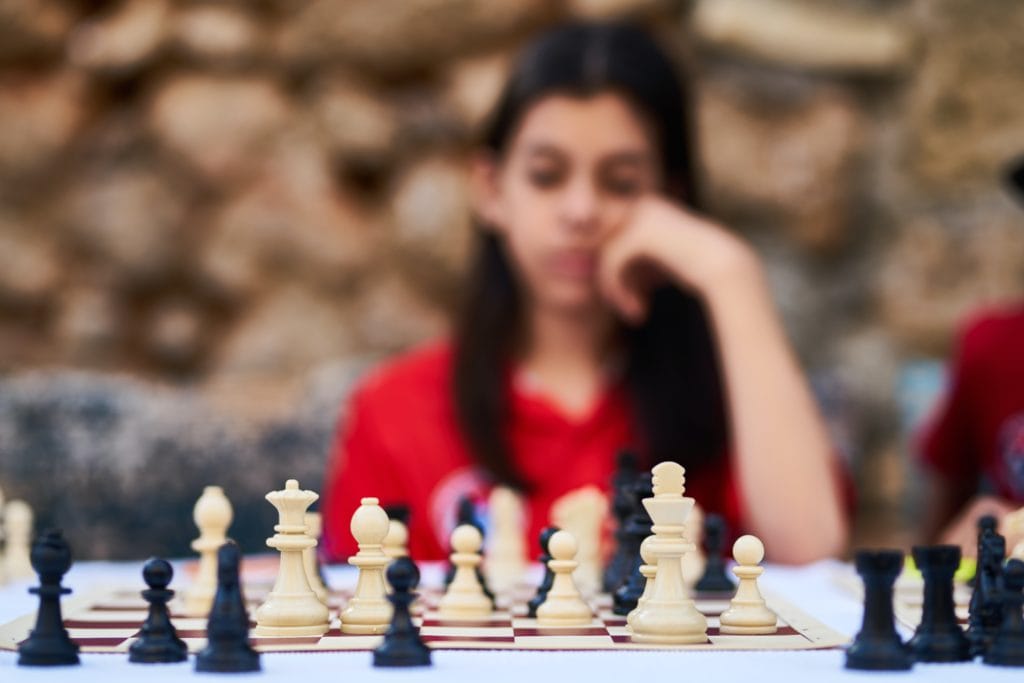 Picture of girl deciding what move to make in a chess game